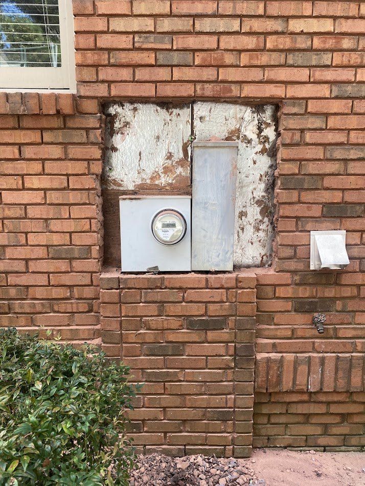 Brick opening enlarged around the old meter and panel