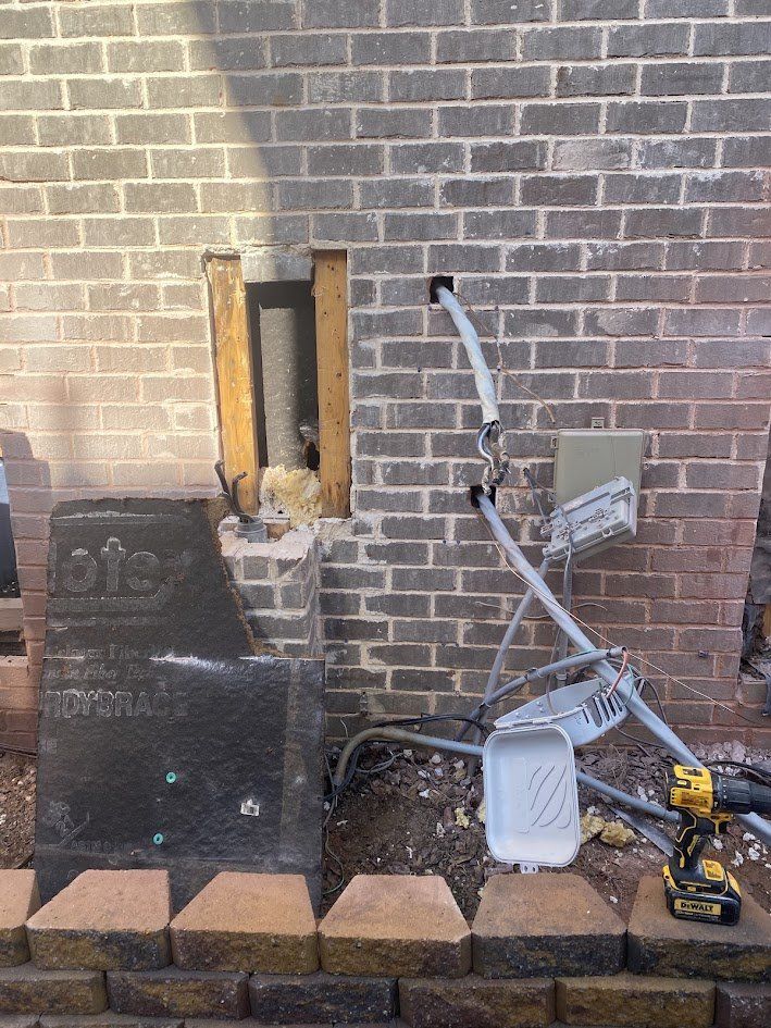 Brick wall opened up and old service equipment removed for the new meter main