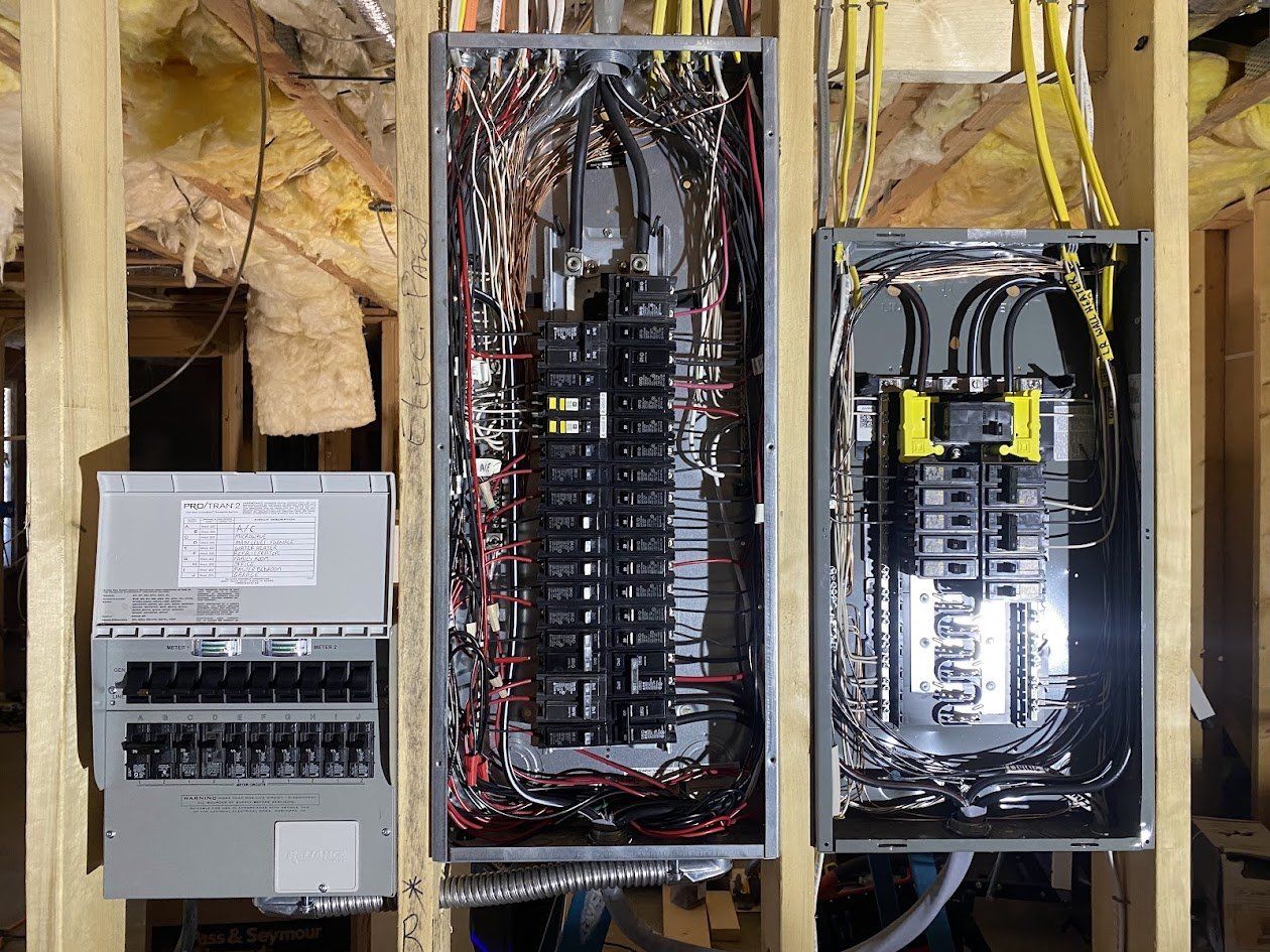 Generator transfer switch installed beside the main panel and a new subpanel in a framed basement