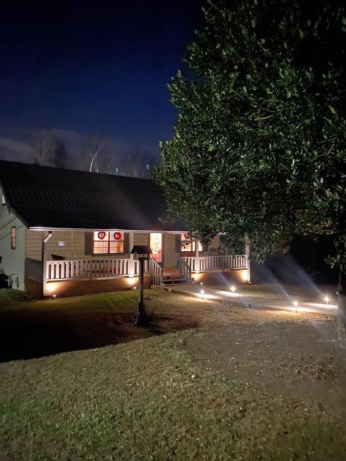 Night view of a home with landscape path lights and porch lighting