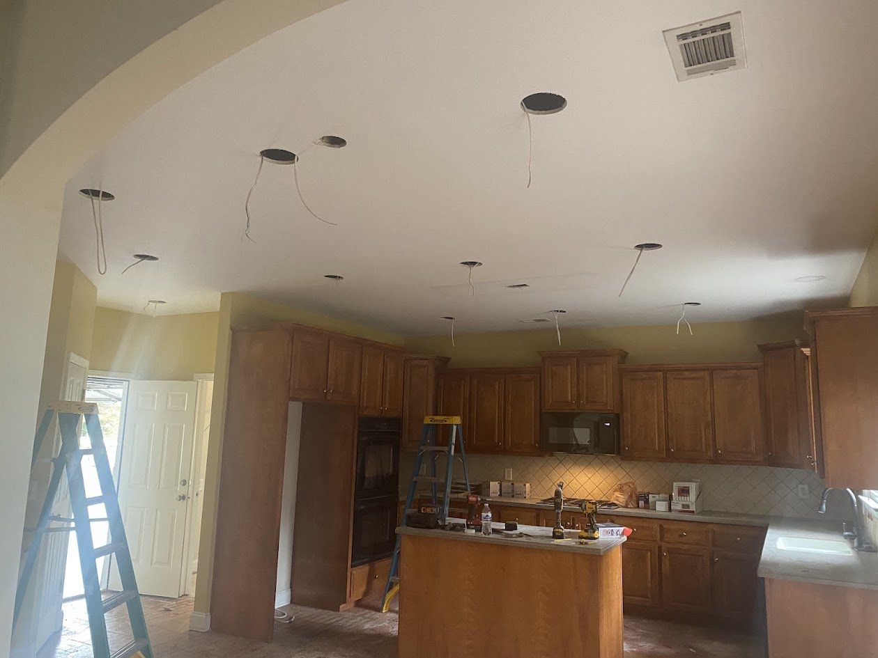 Kitchen ceiling with recessed light cutouts and wiring before fixtures were installed