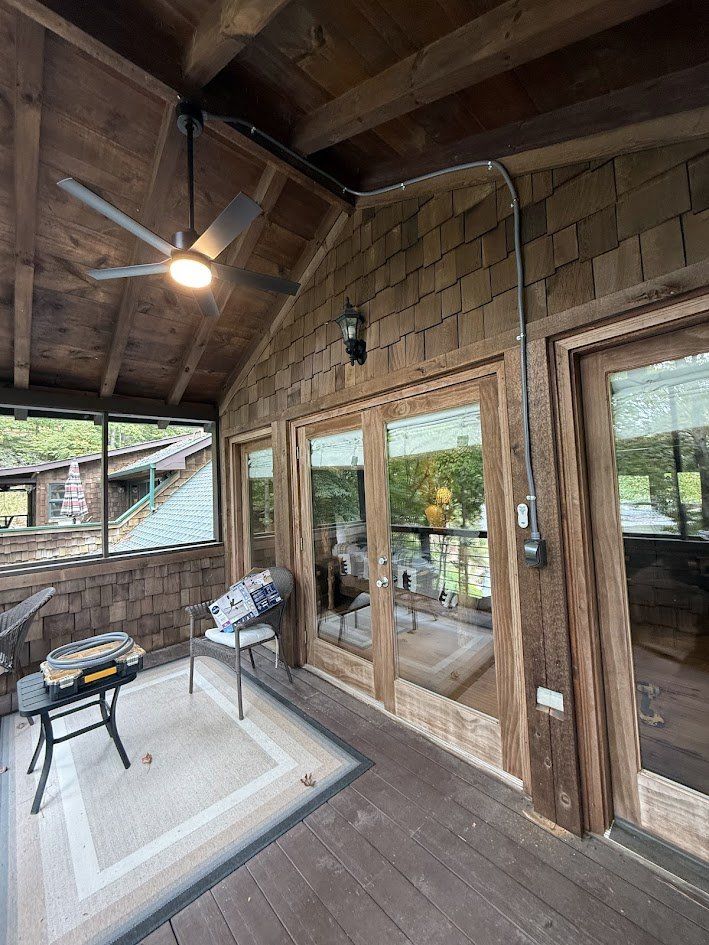 Covered porch with a new ceiling fan, wall lantern and conduit run